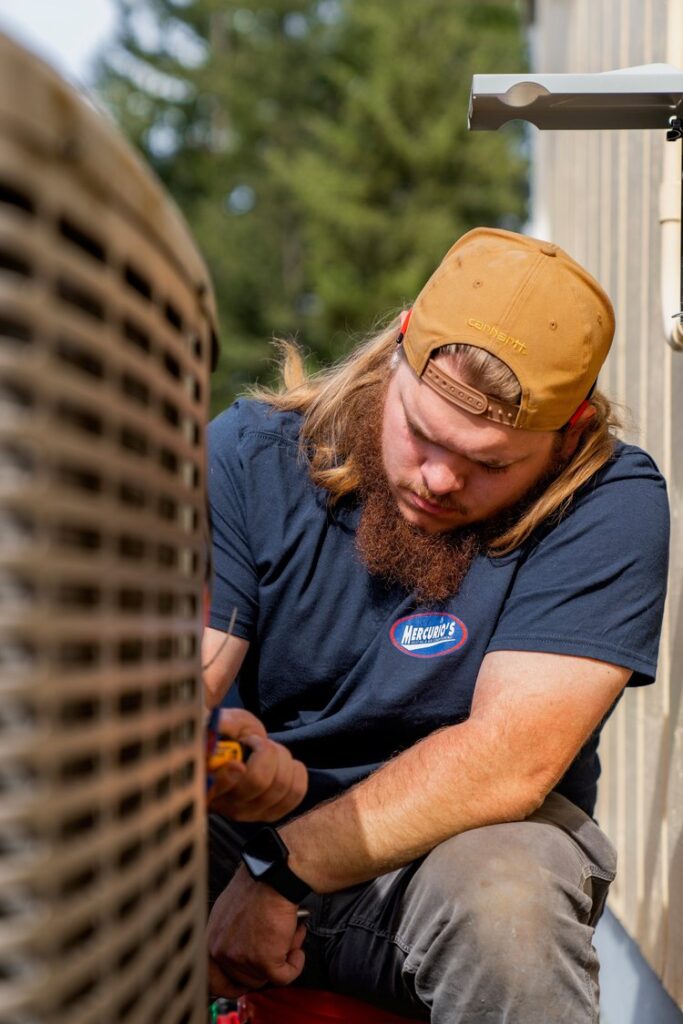 Technician servicing air conditioner